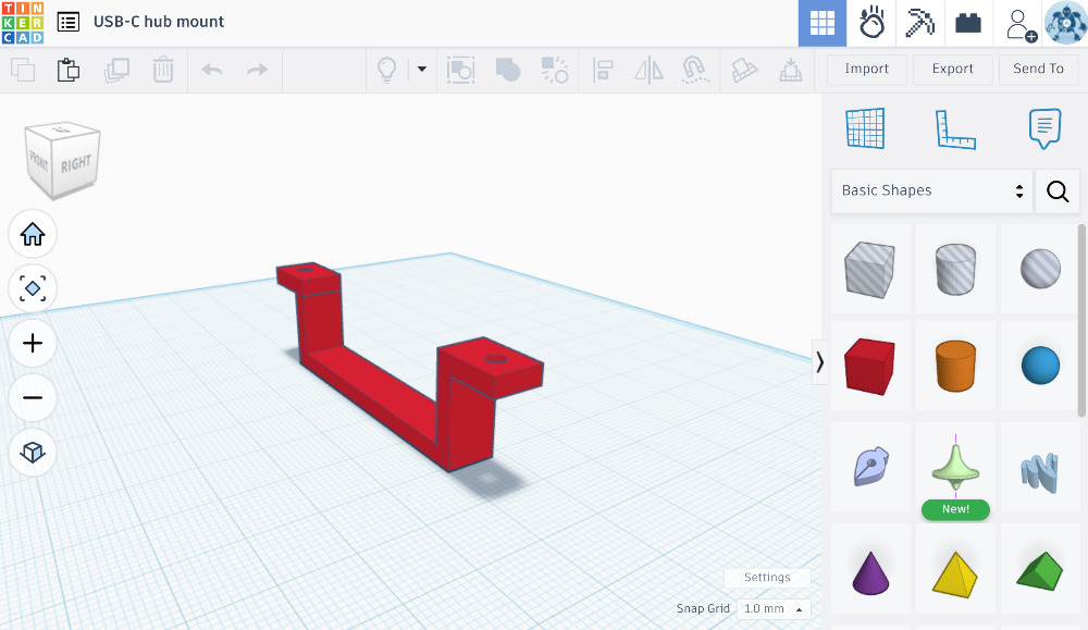 Tinkercad-verkkosovellus on hyvin simppeli, mutta peruspalikoita ja eri muotoisia reikiä/leikkauksia yhdistelemällä voi halutessaan yrittää rakentaa monimutkaisempiakin virityksiä. Kuvassa pöydänaluskiinnityshalaaja USB-C-monitoimihubille.